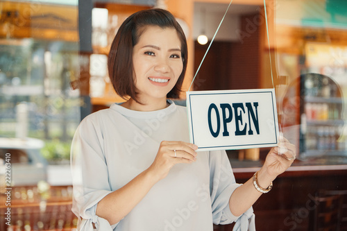 Portrait of pretty Asian female small business owner opening bar