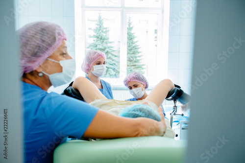 Woman gynecologist, anesthetist and female assistant with hysteroscopy equipment carry out operation in ginecology medical center. photo