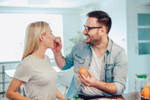 Cute couple eating breakfast in the kitchen and having a good time.