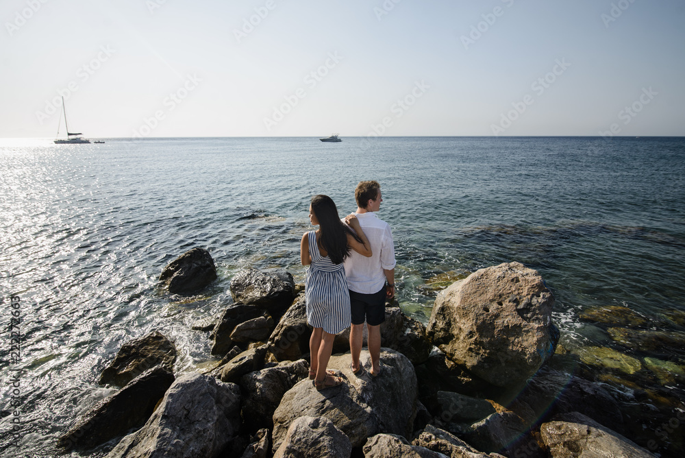 Young couple walking on the background of the sea on the island of Santorini