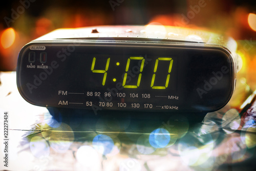 Black digital alarm radio clock.Alarm radio clock indicating time to wake up.Digital clock closeup displaying 4:00 o'clock. photo