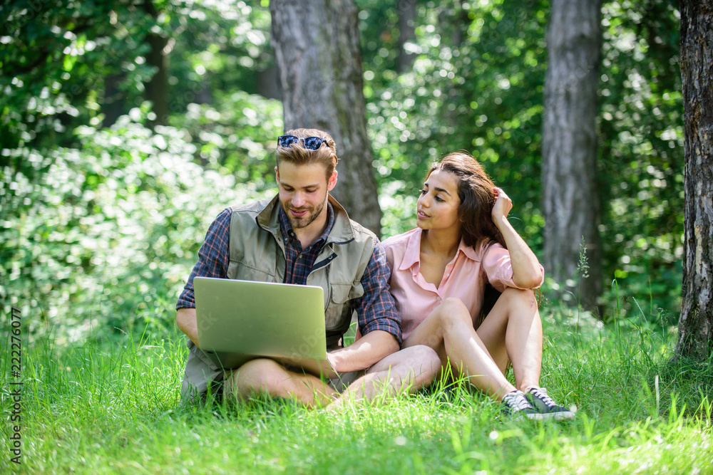 Man and girl working with laptop at green meadow. Freelance opportunity. Modern technologies give opportunity to work in any environment conditions. Couple youth spend leisure outdoors with laptop Man and girl working with laptop at green meadow. Freelance opportunity. Modern technologies give opportunity to work in any environment conditions. Couple youth spend leisure outdoors with laptop