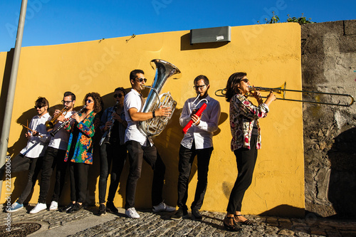 Jazz band, a group of musicians play music on the street near the yellow wall. photo