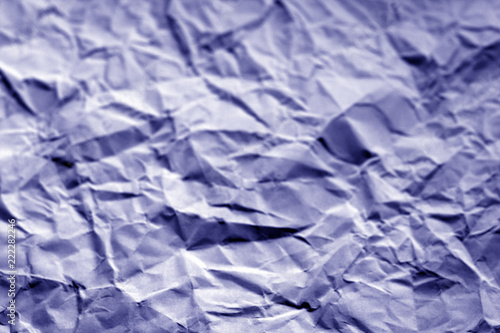 Crumpled sheet of paper with blur effect in blue tone. photo