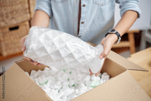 Photos Close-up of woman unpacking her online order, she receiving beautiful vase
