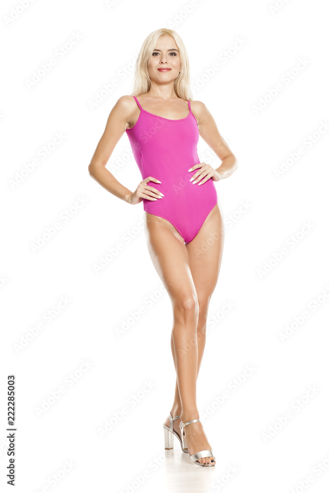 young pretty blonde woman posing in pink sweamsuit on white background young pretty blonde woman posing in pink sweamsuit on white background