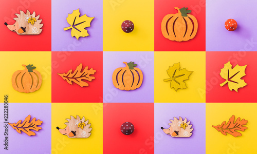 Multicolor checkers of wooden figures autumn elements like leafs, pumpkins, mushrooms, hedgehogs. Fall background.