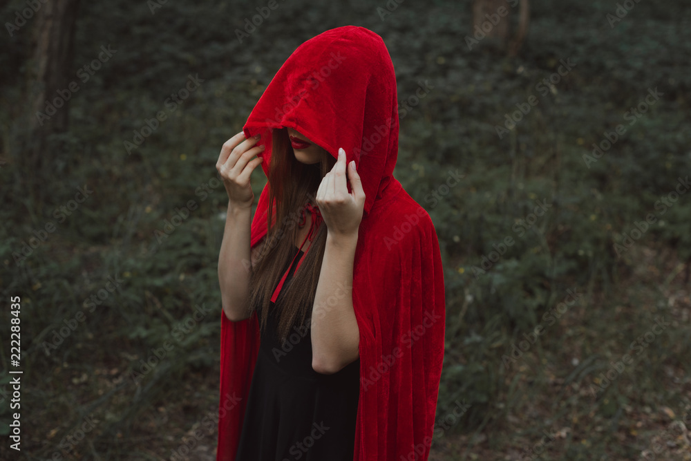 mystic girl in red cloak and hood in forest mystic girl in red cloak and hood in forest