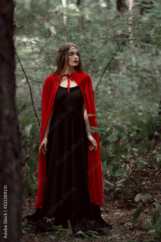 beautiful mystic girl in red cloak in forest