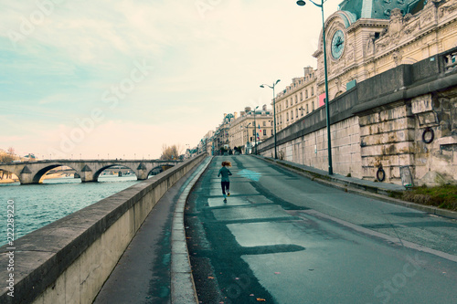 Girl running across quay in Paris. photo