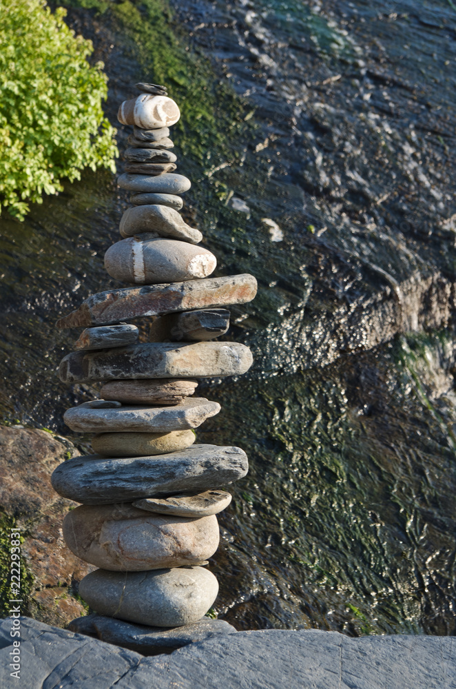 Fototapeta premium Pile of pebble stones and waterfall. Zen and Harmony themes