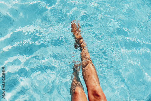 Canvas-taulu beautiful woman legs splashing in the pool