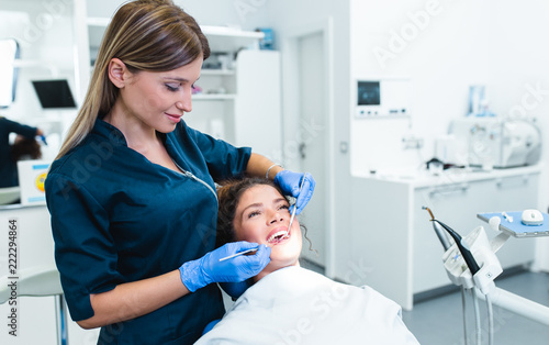 Beautiful young woman having dental treatment at dentist s office.