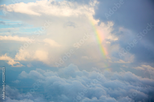 The sun shines on the sky from airplane, View on flight, bird eye view.Over the Clouds. Fantastic background with clouds and mountain peaks.rainbow on the cloud. rainbow in the heaven. photo