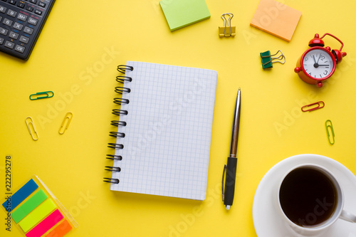 Notepad for text and Cup of coffee yellow table with copy space. Education and office concept.