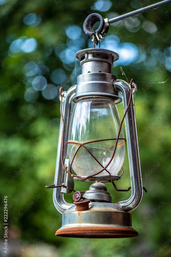 Gas lantern with burning light, on a green background. An antique vintage  lamp. Camping light. Interior decoration. Rusty, covered with patina. Stock  Photo | Adobe Stock