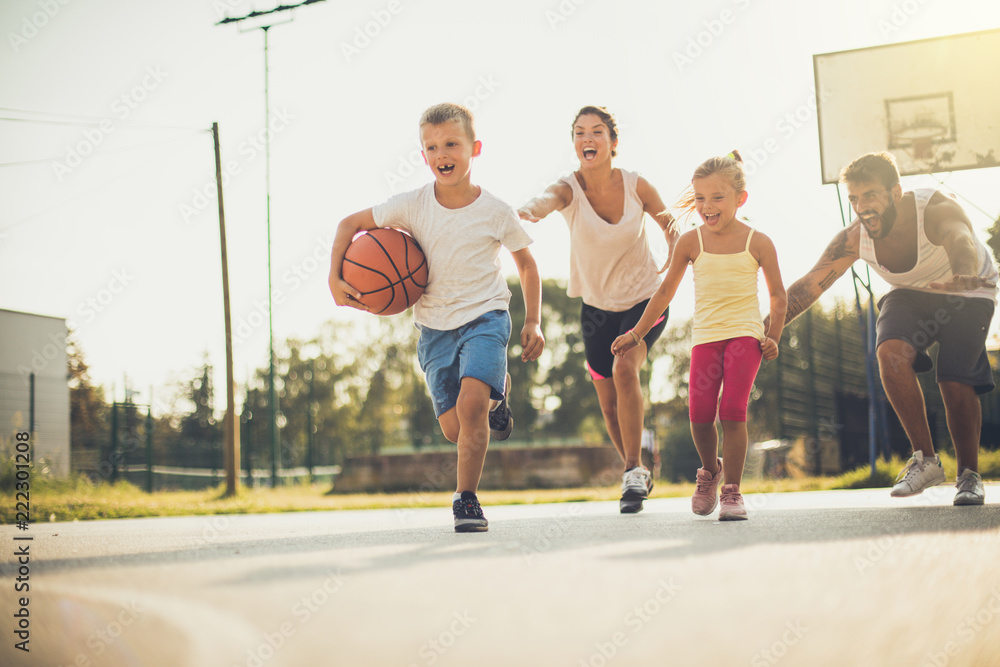 Spring is great for family sport.  Happy family playing basketball outside.