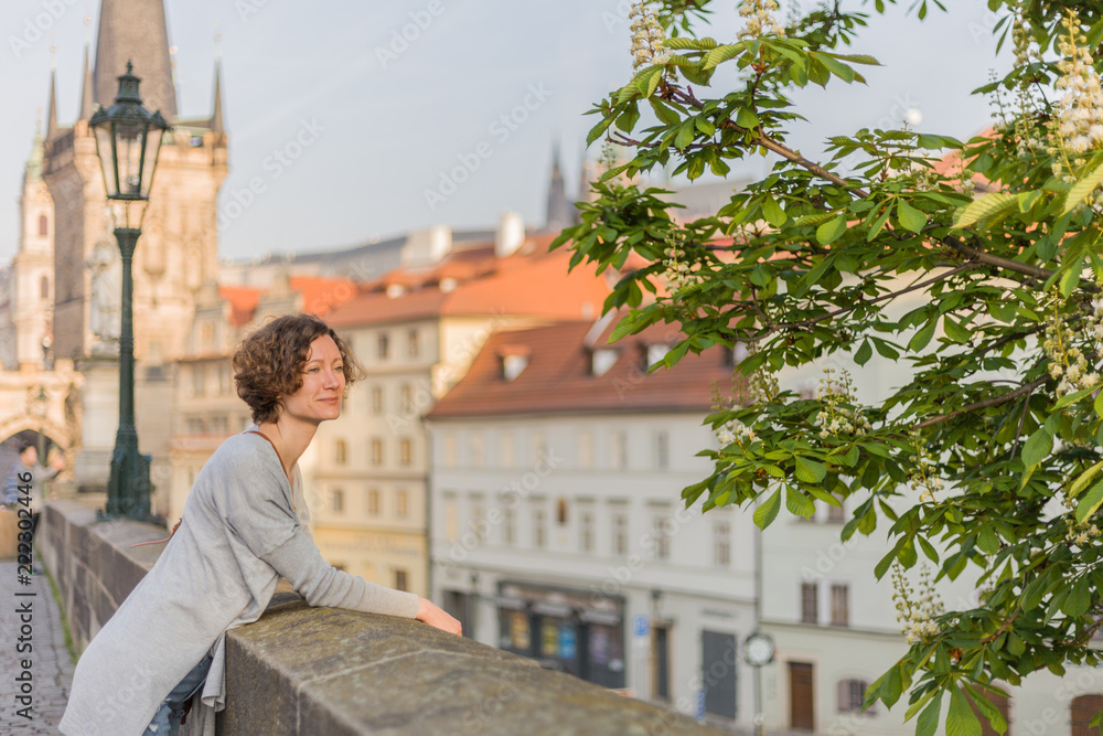 A tourist woman is walking around Prague on a sunny day.