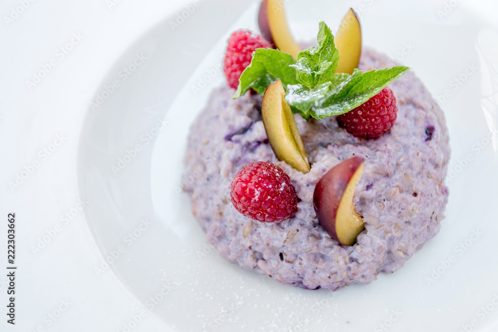 Oatmeal porridge with blueberries, raspberries and peach. Oatmeal porridge with blueberries, raspberries and peach.