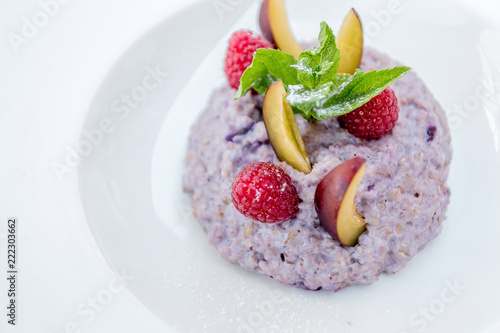 Oatmeal porridge with blueberries, raspberries and peach.