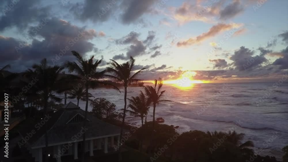 Aerial view of sunset over ocean in tropical paradise. big waves, palms