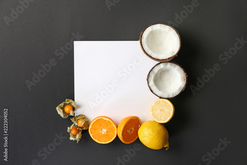 Composition with various delicious exotic fruits and blank card on dark background