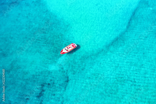 Luftaufnahme eines Motorbootes über kristallklarem, türkisem Meer der Kykladen in Griechenland