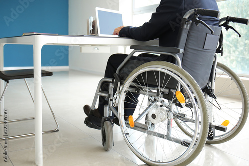 Businessman in wheelchair working in office © Pixel-Shot