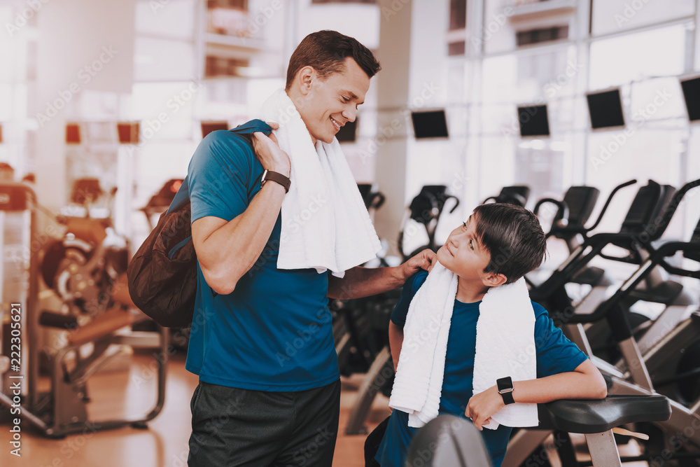 Young Father and Son near Treadmills in Modern Gym Young Father and Son near Treadmills in Modern Gym