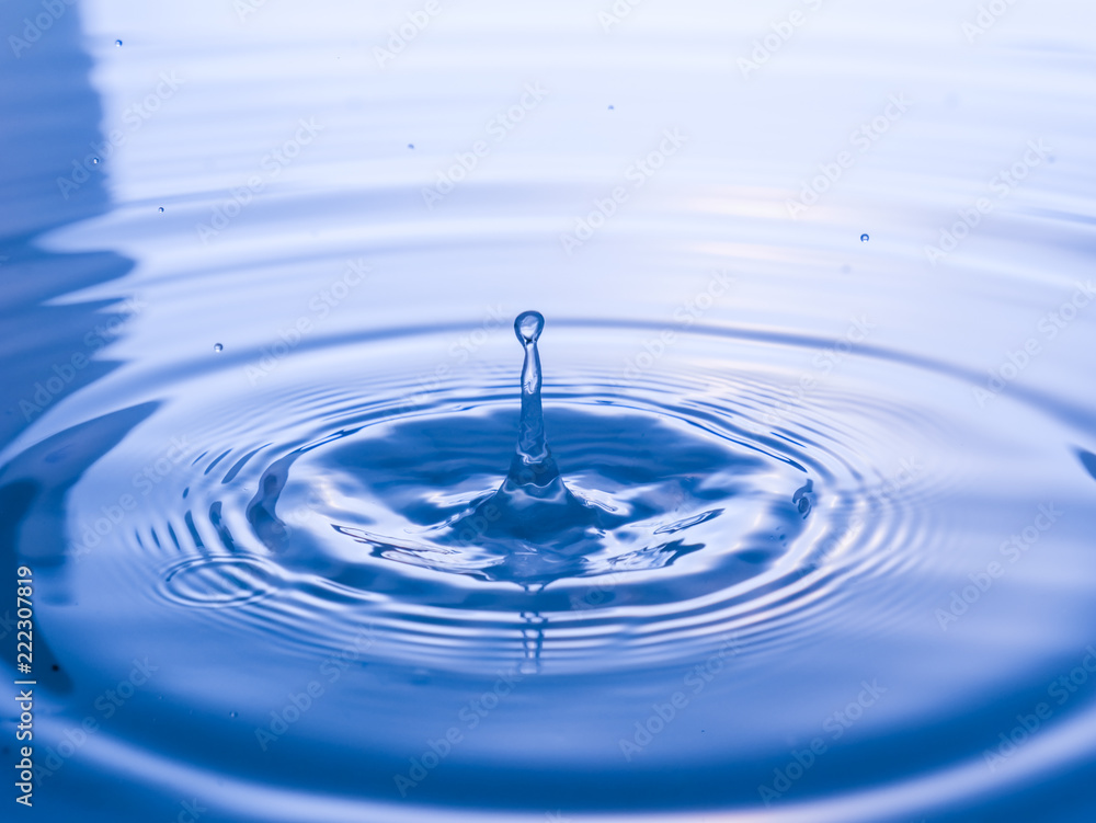 close up drop of water on blue background close up drop of water on blue background