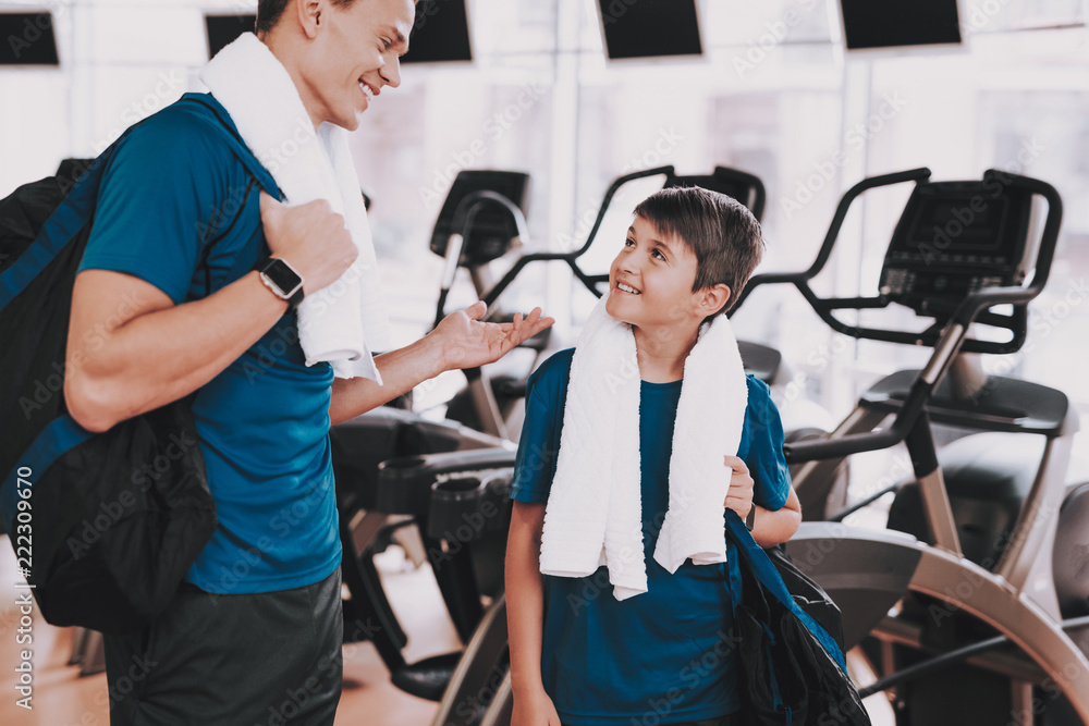 Young Father and Son near Treadmills in Modern Gym Young Father and Son near Treadmills in Modern Gym