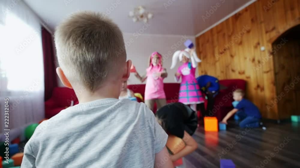 Children and animators throw soft cubes at each other. In the foreground, a little boy throws a die. A children's party. Children and animators throw soft cubes at each other. In the foreground, a little boy throws a die. A children's party.