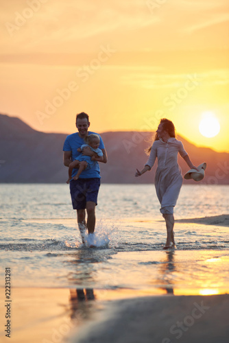 family walks at sunset along the beach