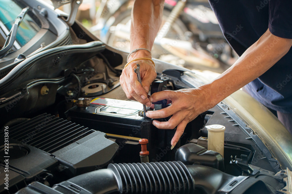 Engine engineer is replacing car battery because car battery is depleted. concept car maintenance Engine engineer is replacing car battery because car battery is depleted. concept car maintenance