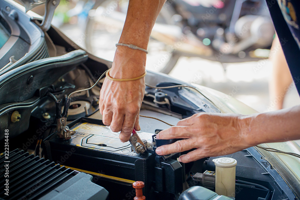 Engine engineer is replacing car battery because car battery is depleted. concept car maintenance Engine engineer is replacing car battery because car battery is depleted. concept car maintenance