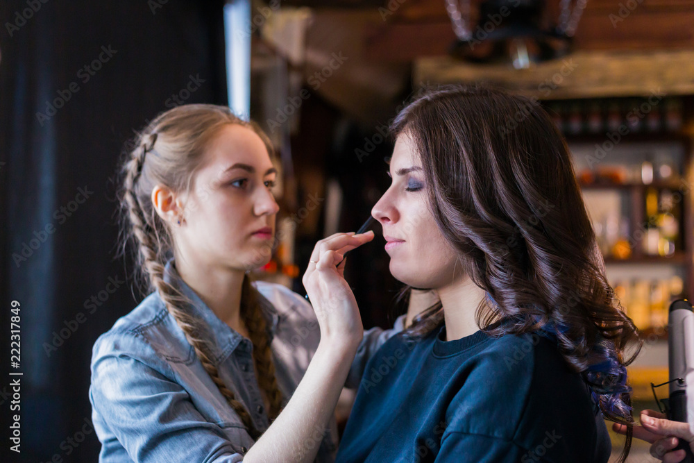 Professional make-up artist working with woman client. Beauty, visage and make up concept Professional make-up artist working with woman client. Beauty, visage and make up concept