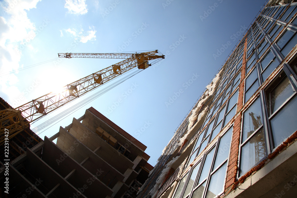 Working crane on the construction of the house. Construction of a residential multi-storey building. New residential area. Working crane on the construction of the house. Construction of a residential multi-storey building. New residential area.