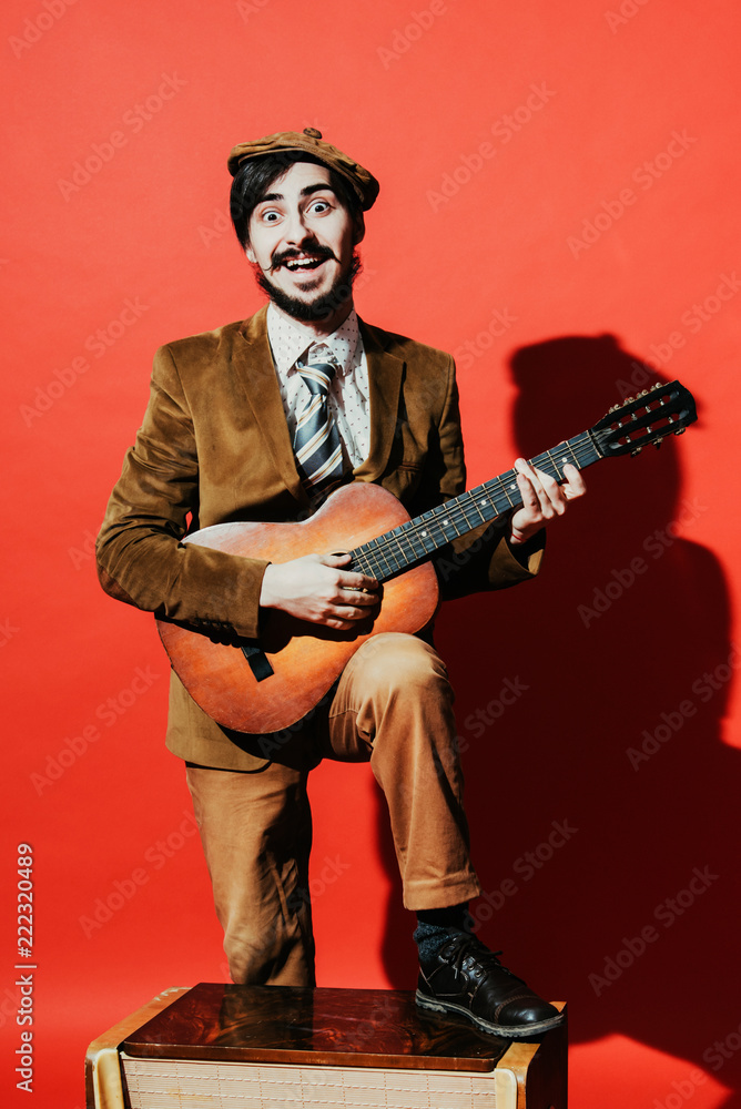 positive guy playing guitar in the Studio
