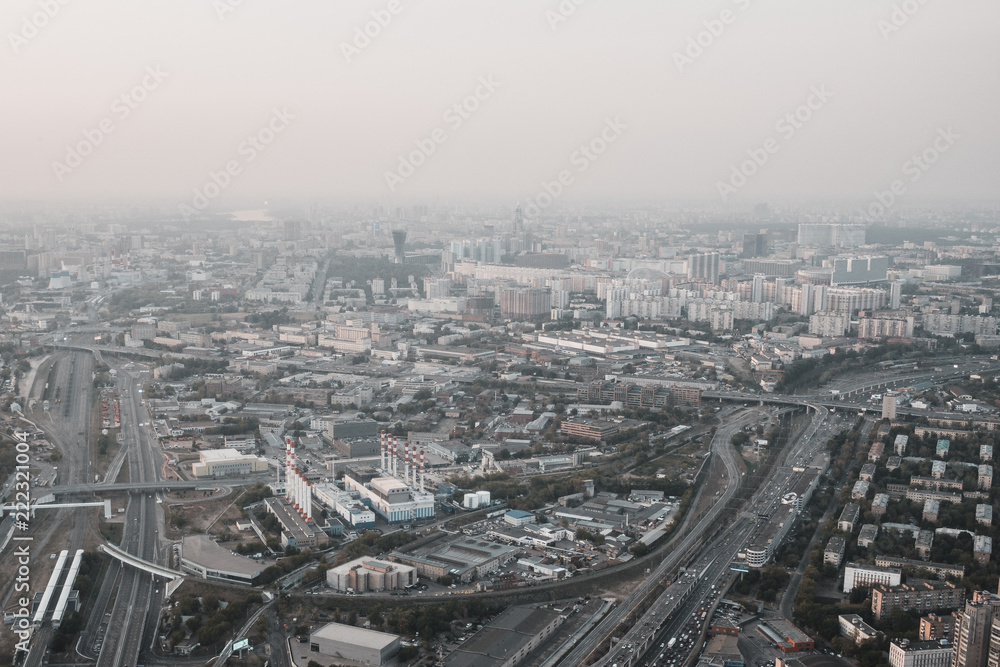 Aerial top view of Moscow city from above, roads with car traffic, cityscape panorama, buildings in evening dusk