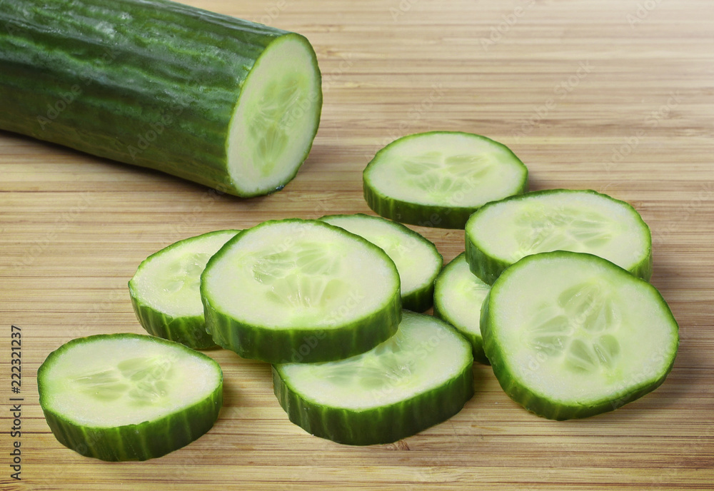 Fresh cucumber on a wooden cutting board. Close up shot of whole cucumber, arrangement or pile. Fresh cucumber on a wooden cutting board. Close up shot of whole cucumber, arrangement or pile.