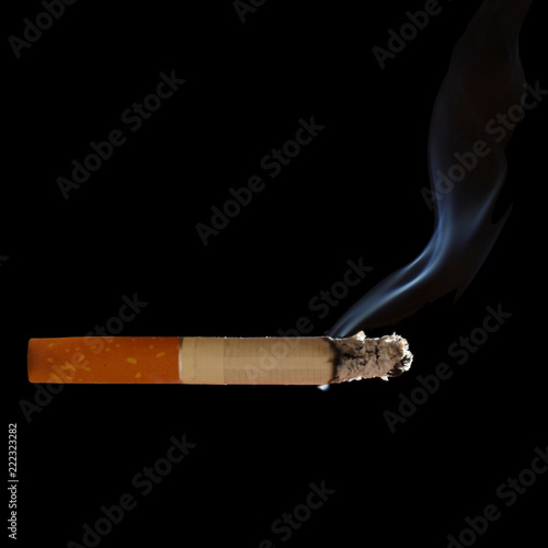 half-smoked cigarette closeup makes smoke curl, isolated on black background