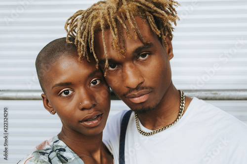 African american couple posing by a wall