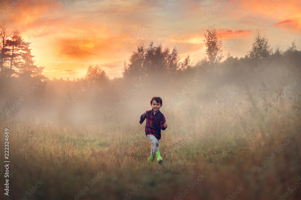 boy running in the field at the sunset boy running in the field at the sunset