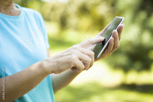 Woman using smart phone with blank black screen at outdoor