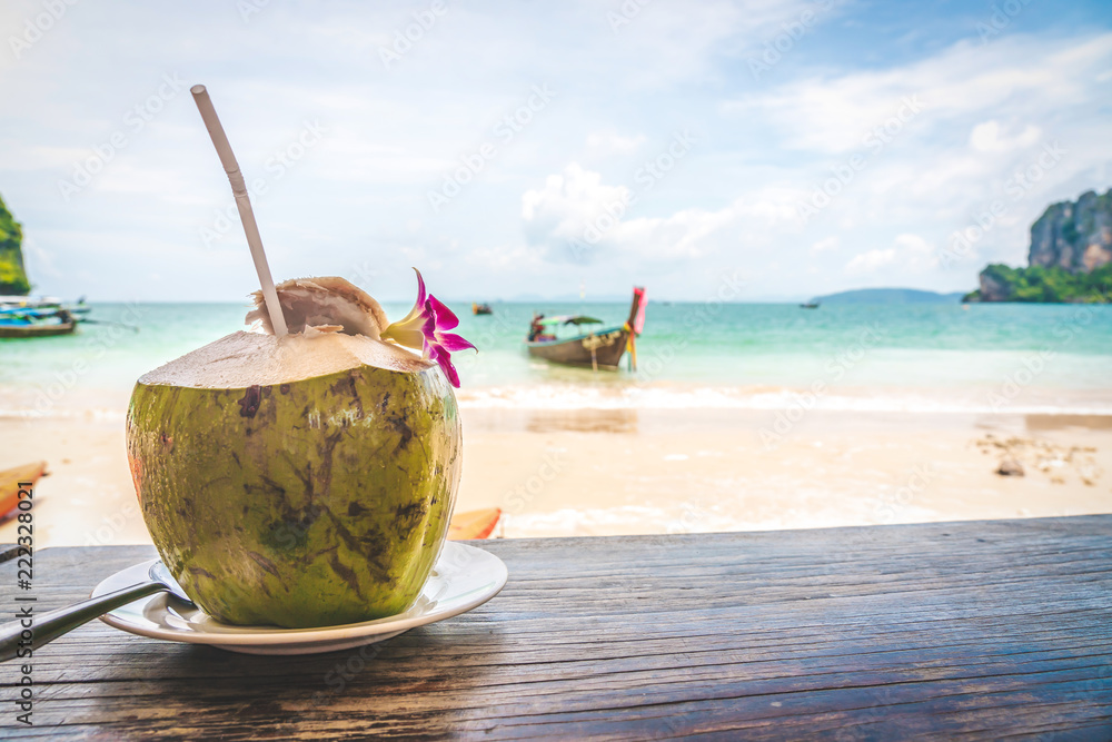 Coconut fruit drink at beautiful Tropical Beach blue ocean background with Traveler items vacation travel accessories for holiday or long weekend a guide choice idea for planning travel Coconut fruit drink at beautiful Tropical Beach blue ocean background with Traveler items vacation travel accessories for holiday or long weekend a guide choice idea for planning travel
