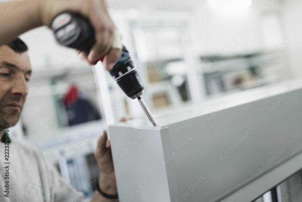 Manual worker assembling PVC doors and windows. Manufacturing jobs