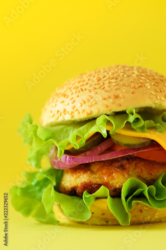 Fresh meat burgers on yellow background. Take away meal. Fast food concept. Unhealthy diet with copy space