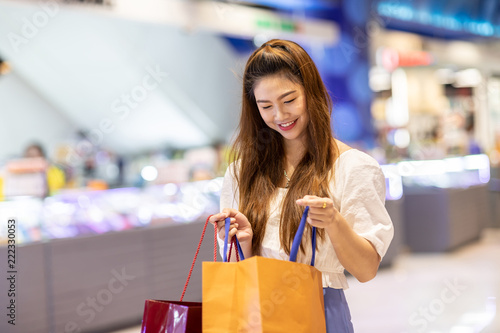 Beautiful Attractive Asian woman open shopping bags after shopping smile and enjoy with it in shopping mall so happiness and cheerful,Shopping Concept