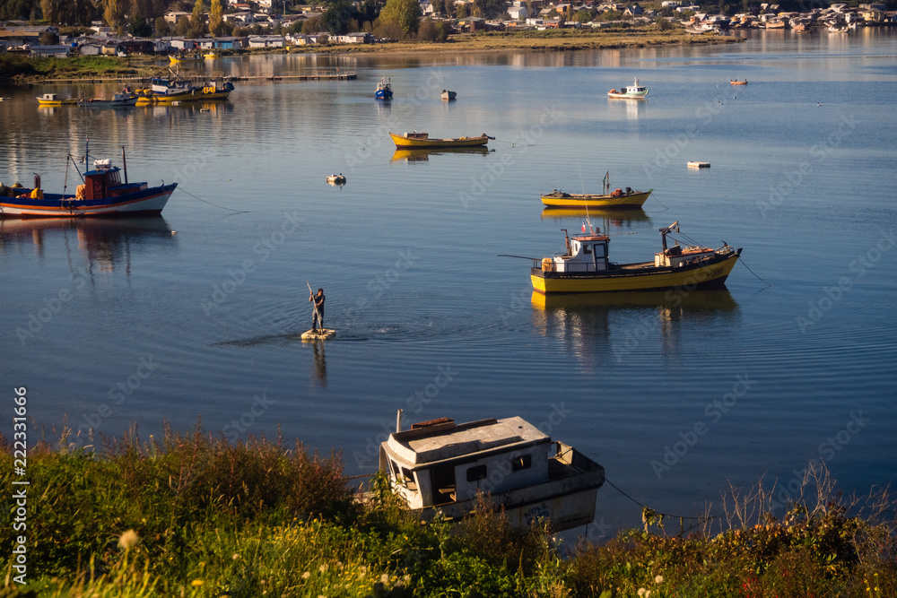 Fisherman rows to his fishing boat in Quellón, Chiloe Island In Chile