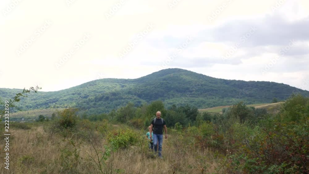 Family walks along the path in the mountains. Hiking with the family Family walks along the path in the mountains. Hiking with the family